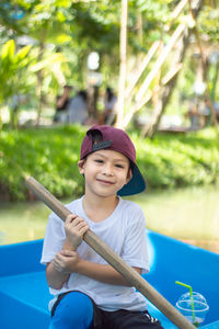 Portrait of boy rowing boat in water