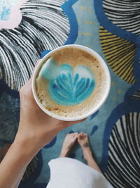 Low section of woman holding coffee cup