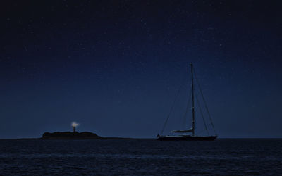 Sailboat sailing on sea against sky at night