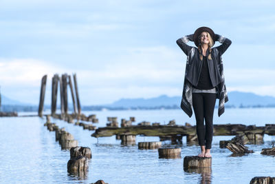 Woman stands barefoot on a post in bellingham, wa