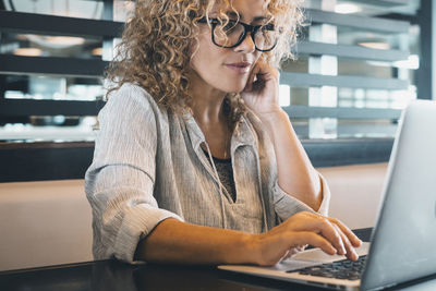 Young woman using laptop at table