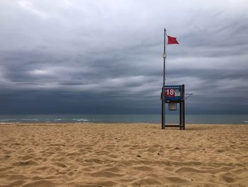 Lifeguard hut on beach against sky