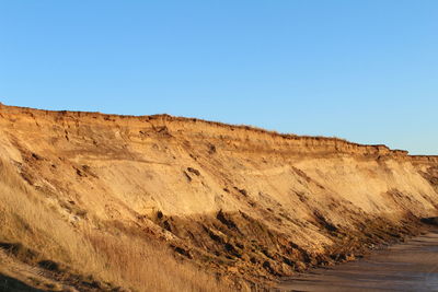 Scenic view of desert against clear blue sky