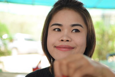 Close-up of smiling young woman looking down while sitting indoors