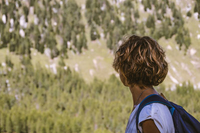 Rear view of man standing against trees