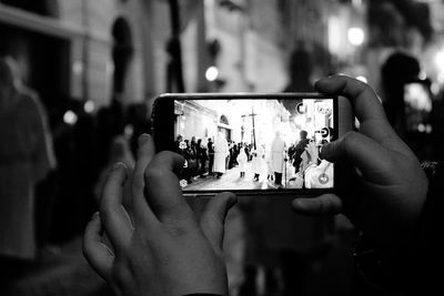 Midsection of man photographing with mobile phone