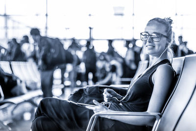 Side view of a woman sitting on mobile phone