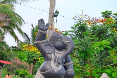Low angle view of statue against trees
