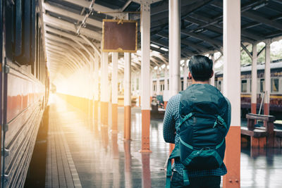Rear view of man walking in corridor