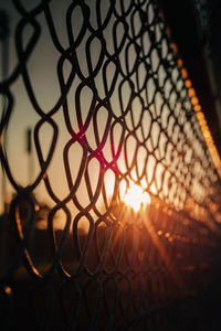 Close-up of chainlink fence during sunset