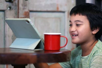 Portrait of smiling young woman using laptop