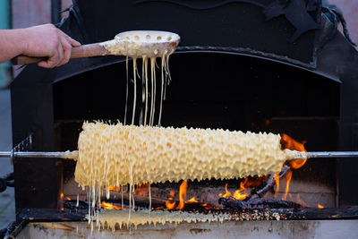 Preparing or baking sakotys with wooden spoon, lithuanian and polish traditional sweet tree cake