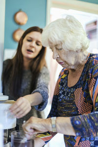 Grandmother and granddaughter preparing coffee at home