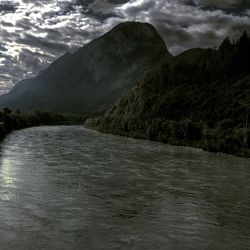 Scenic view of river amidst mountains against sky