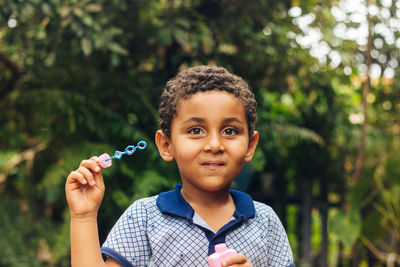 Portrait of boy holding plant