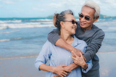 Happy couple standing on beach