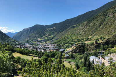 Aerial view of townscape by mountains against sky