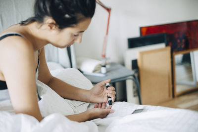 Young woman lying on bed at home