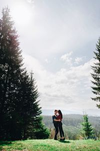 Full length of young couple standing face to face in forest