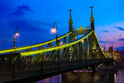 View of bridge over river at night