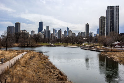 River amidst buildings in city against sky