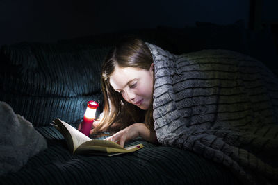 Portrait of a girl reading on sofa at home