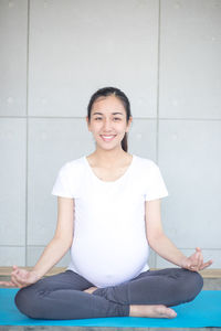 Portrait of smiling young man sitting on floor
