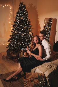 A romantic couple in love celebrates christmas holidays and new year in a cozy house at night