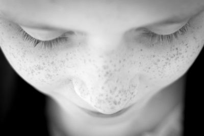 Close-up portrait of beautiful woman against black background