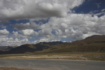 Scenic view of land and mountains against sky