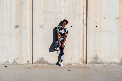 Full length of boy standing against wall