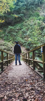 Rear view of man walking on footpath