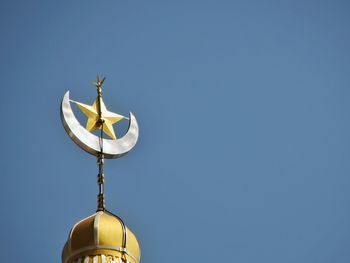 Low angle view of star and crescent on minaret against clear sky