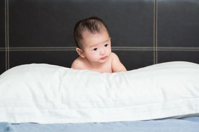Close-up of cute baby boy on bed