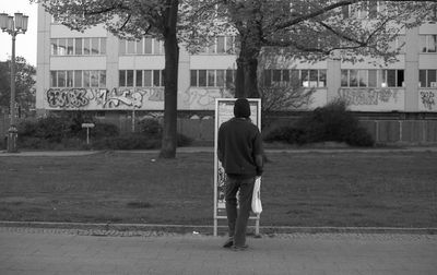 Rear view of man walking on road