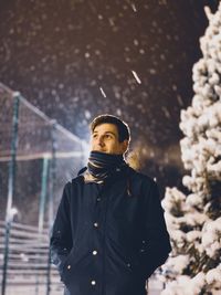 Portrait of young man standing in snow