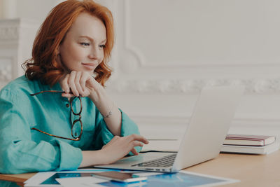 Businesswoman using laptop at desk in office