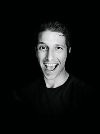 Portrait of young man against black background