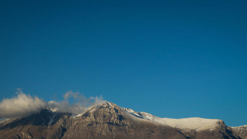 Scenic view of snowcapped mountains against clear blue sky