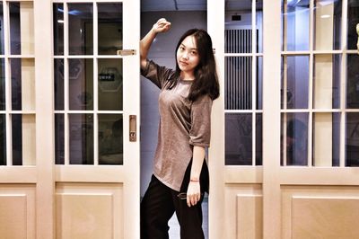 Portrait of young woman standing on wall