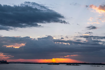 Scenic view of sea against dramatic sky during sunset