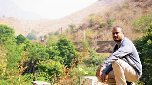 Portrait of young man sitting on mountain