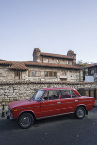 Vintage car against building in city against clear sky