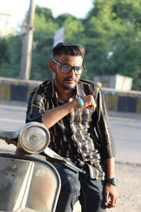 Young man riding sunglasses sitting on motorcycle