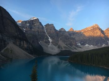 Scenic view of lake by mountains against sky