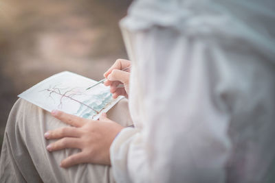 Midsection of woman holding umbrella