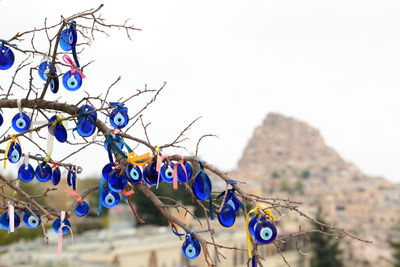 Close-up of clothespins hanging on rope against clear blue sky