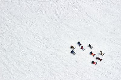 High angle view of friends on snow covered field