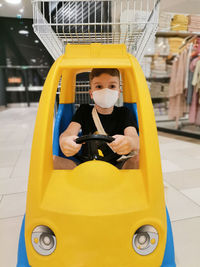Boy with protective face mask in shopping mall during coronavirus epidemic.