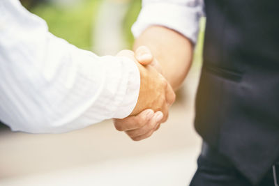 Midsection of couple holding hands